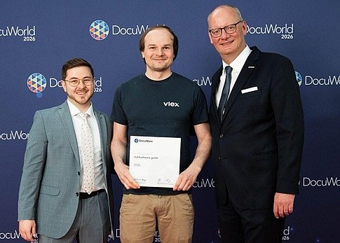 Marco Kilchenstein und Hermann Schaefer (DocuWare) überreichen Christopher Roth (VLEX) den Award auf der Partnerkonferenz DocuWorld 2026 in Berlin. Für VLEX ist die Auszeichnung Anerkennung und Verpflichtung zugleich. (Bild: Docuware GmbH)