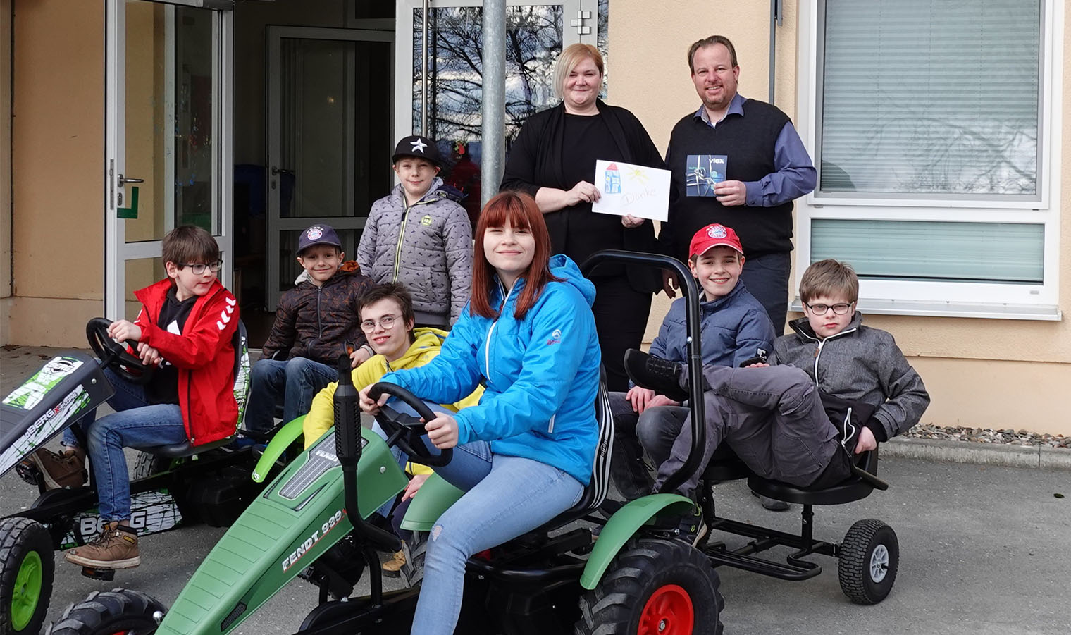 Begeisterte Kinder und Jugendliche präsentieren Geschäftsführer Jens Pfeil-Schneider die neuen Kettcars bei der Spendenübergabe. 